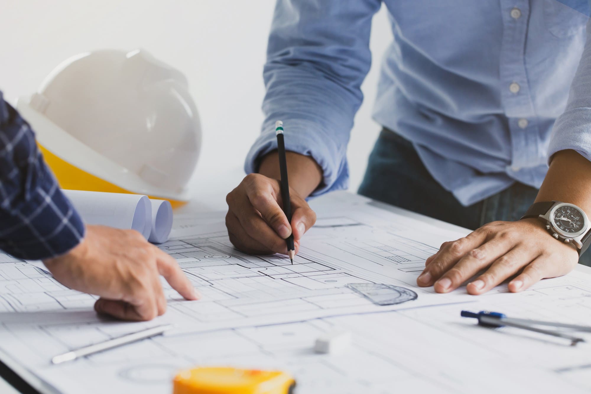Deux professionnels en train d’analyser un plan de bâtiment pour planifier des interventions à long terme
