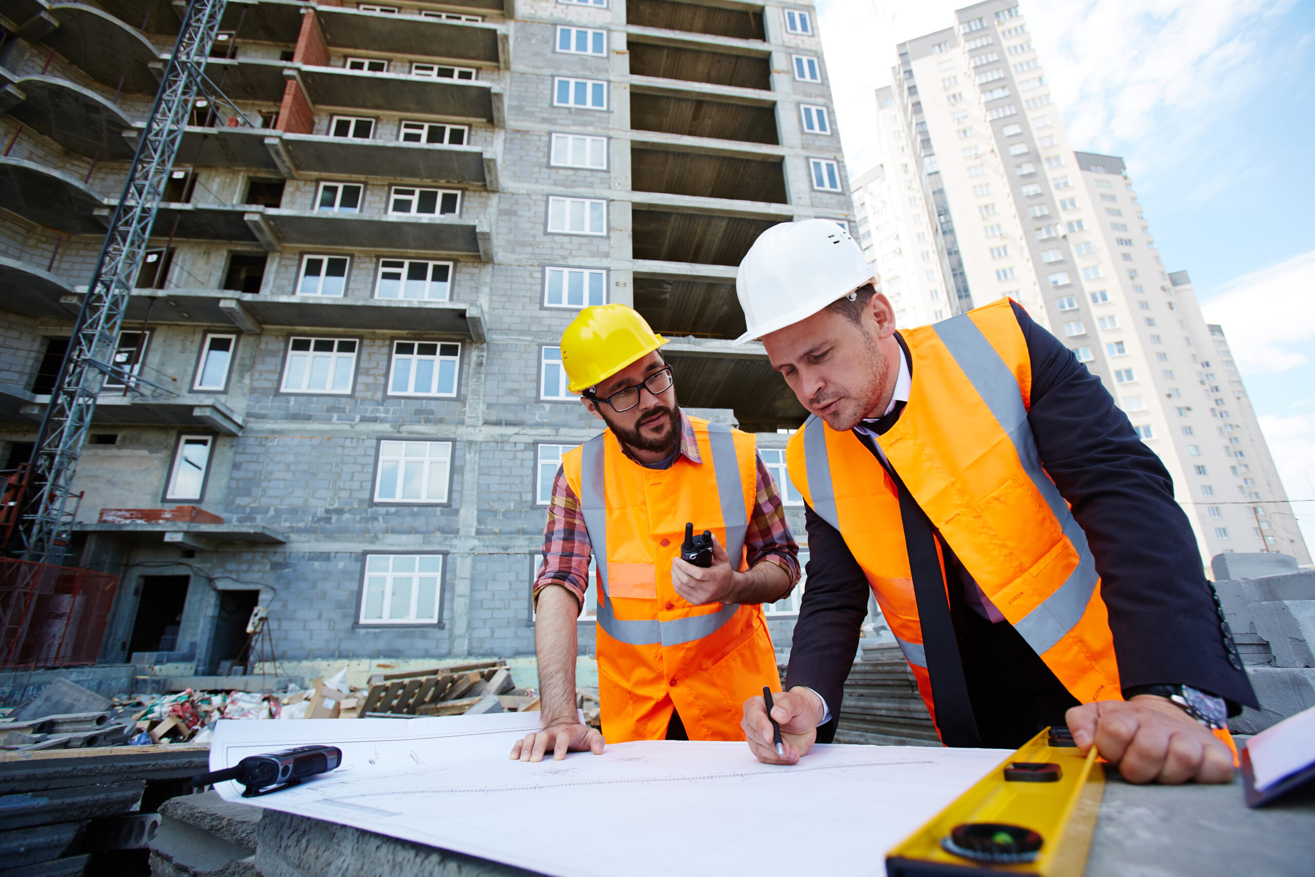 Pointing at sketch Modern engineer pointing at sketch in blueprint while explaining it to colleague