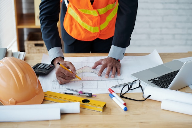 Plan d’ingénierie sur table avec outils de mesure et casque de sécurité